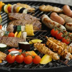 Brochettes de poulet, saucisses, steaks et légumes colorés, une belle variété de viande à faire au barbecue pour un repas convivial.