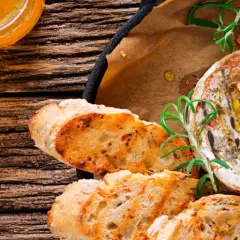 Un délicieux fromage au barbecue, doré et fondant, servi avec du pain grillé et du romarin frais.