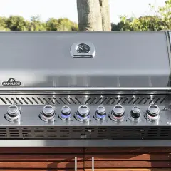 Barbecue à gaz Napoleon avec couvercle fermé, prêt pour de nouvelles recettes. Ses boutons lumineux indiquent la température parfaite.
