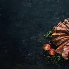 Côte de bœuf tranchée, saignant, avec une texture bleu parfaite. Sel, romarin et tomates cerises accompagnent ce plat.