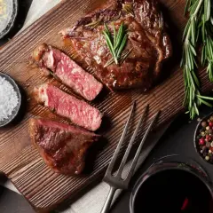 Un steak juteux, tranché, avec du romarin, du sel et du poivre. Une image parfaite pour apprendre comment fumer de la viande.
