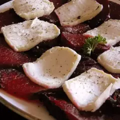 Tranches de betterave au barbecue, garnies de fromage de chèvre frais et d'herbes. Un délice estival.