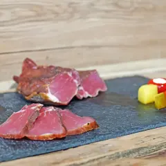 Filet mignon tranché, prêt pour le temps de salage avant fumage. Accompagné de poivrons rouges, cornichons et fromage.