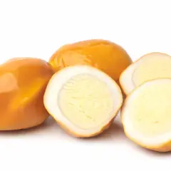Œufs fumés entiers et coupés en deux, révélant un jaune d'œuf crémeux.