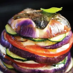 Délicieux légumes à la plancha, un empilement coloré d'aubergines, courgettes et tomates, avec une touche de pomme de terre cachée.