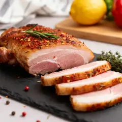 Pluma de porc recette : un rôti de porc juteux, coupé en tranches, assaisonné d'épices et de romarin, prêt à être dégusté.