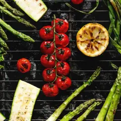 Légumes au barbecue charbon de bois : asperges, tomates cerises, courgettes, oignons nouveaux, citron et chou.