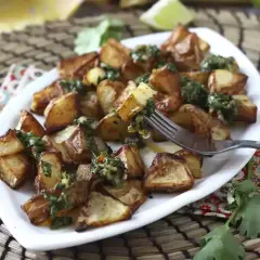 Pommes de terre rôties, garnies d'une sauce verte fraîche, prêtes à être dégustées. Un délice parfait pour un repas d'été, comme un coulommier au barbecue.