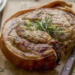 Rouelle de porc au barbecue, dorée et savoureuse, garnie de romarin et de thym. Un délice à partager !