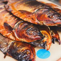 Poissons fumés, dorés et appétissants, prêts à être dégustés. Un délice de poisson au brasero.