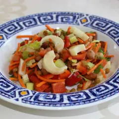 Salade colorée avec des cœurs de palmier, carottes râpées, lentilles et poivrons rouges. Un délice frais et sain.