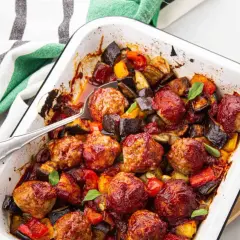 Un plat réconfortant de boulettes de viande barbecue, enrobées d'une sauce savoureuse, mijotant avec des légumes rôtis comme l'aubergine et le poivron.