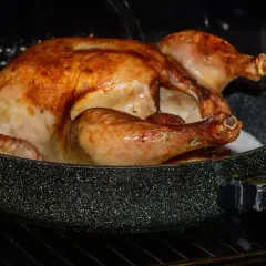 Un poulet crapaudine doré et juteux cuit dans un plat au four, prêt à être dégusté.