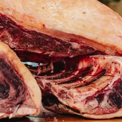Gros morceaux de bœuf, prêts pour le dry aging, révélant une viande rouge foncée et une belle couche de gras.