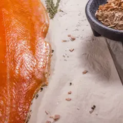 Filet de saumon fumé, sel, poivre et copeaux de bois. Quelle sciure pour fumoir ? Des copeaux de bois pour un fumage parfait.