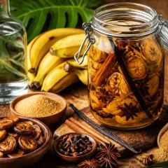 Préparation d'une recette rhum arrangé banane : bananes, sucre, cannelle, anis étoilé, vanille et rhum blanc.