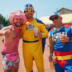 Trois amis costumés pour une soiree brasero, l'un en rose flashy, l'autre en "Pastis Man" jaune, et le dernier en super-héros "Beer".