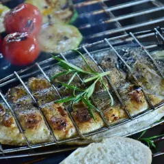 Dorade grillée sur barbecue Weber, avec tomates et courgettes. Le temps de cuisson est parfait pour ce plat savoureux.