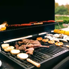 Viande, crevettes, huîtres et maïs sur un barbecue à gaz. Le fumage barbecue gaz ajoute une saveur délicieuse.