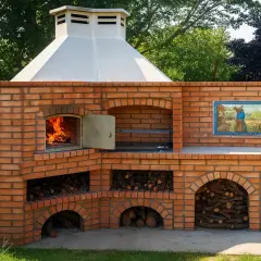 Un grand barbecue en briques, avec un feu qui crépite et du bois rangé, prêt pour un repas rustique au barbecue.