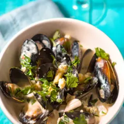 Délicieuses moules au roquefort, nage crémeuse, persil frais et éclats de fromage bleu. Un délice !