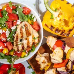 Une salade verte fraîche avec poulet grillé, tomates, poivrons et fromage. Accompagnée de brochettes, courgettes grillées et saucisses.