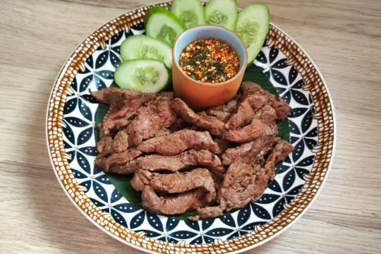 Bœuf grillé et fines tranches de concombre, accompagnés d'une sauce tigre qui pleure épicée.