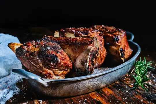 Succulente viande plancha, grillée à la perfection, servie dans un plat en métal avec du romarin frais.