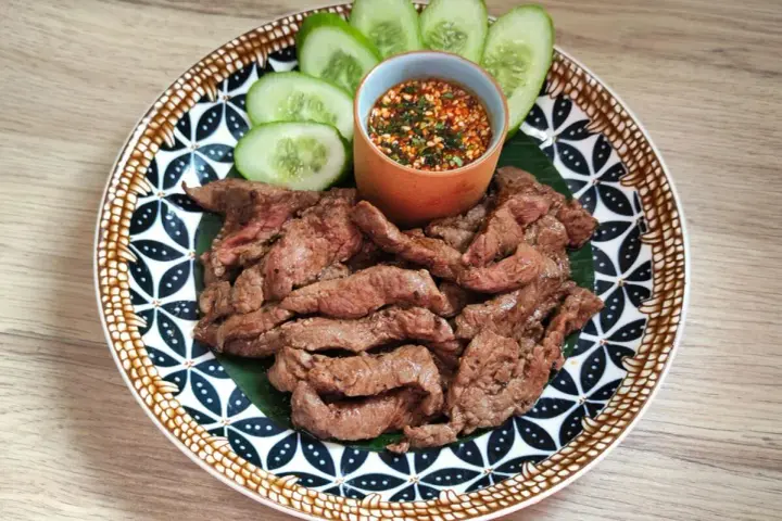 Bœuf grillé et fines tranches de concombre, accompagnés d'une sauce tigre qui pleure épicée.