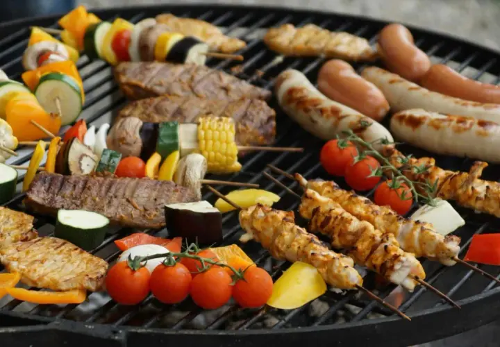 Brochettes de poulet, saucisses, steaks et légumes colorés, une belle variété de viande à faire au barbecue pour un repas convivial.
