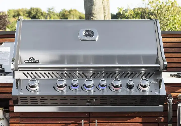 Barbecue à gaz Napoleon avec couvercle fermé, prêt pour de nouvelles recettes. Ses boutons lumineux indiquent la température parfaite.