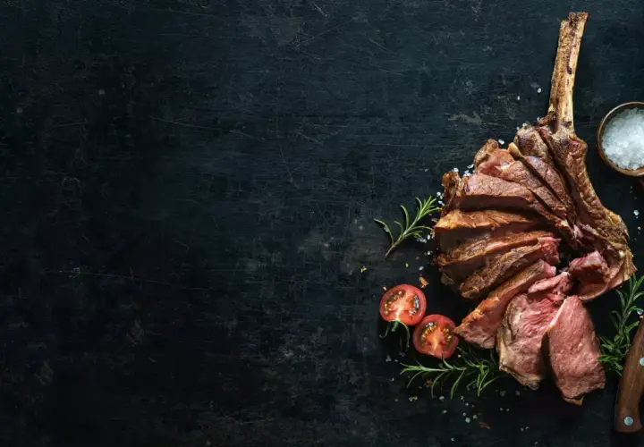 Côte de bœuf tranchée, saignant, avec une texture bleu parfaite. Sel, romarin et tomates cerises accompagnent ce plat.