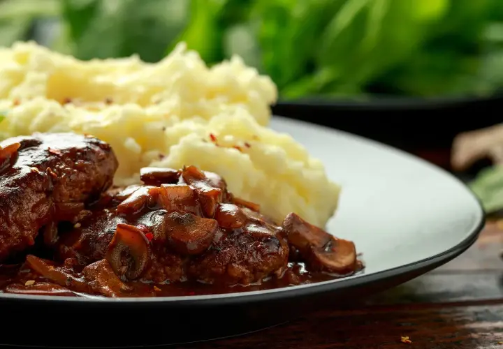 Délicieuses joues de bœuf mijotées dans une sauce aux champignons, servies avec une purée de pommes de terre onctueuse.