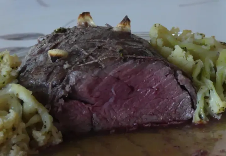 Un rôti de bœuf des Highlands, saignant et tendre, servi avec du chou-fleur rôti aux herbes.