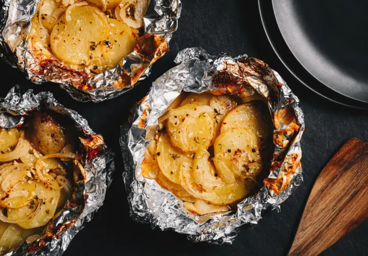 Pommes de terre en papillote, idéales pour un barbecue au gaz. Savoureuses et tendres, elles sont prêtes à être dégustées.