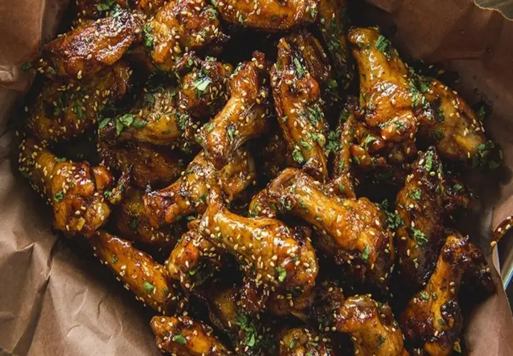Ailes de poulet caramélisées, saupoudrées de sésame et de persil. Parfaites pour le temps de cuisson ailes de poulet sur bbq.