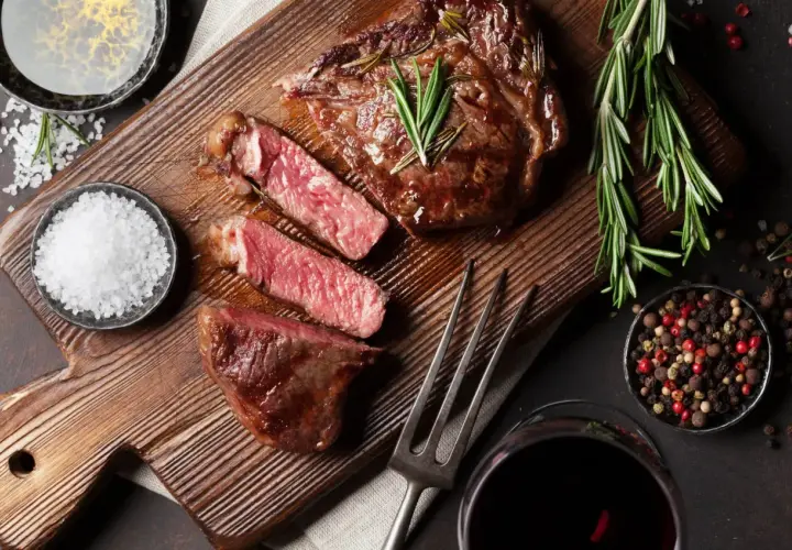 Un steak juteux, tranché, avec du romarin, du sel et du poivre. Une image parfaite pour apprendre comment fumer de la viande.