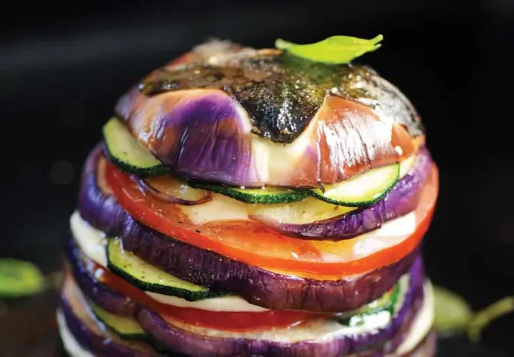 Délicieux légumes à la plancha, un empilement coloré d'aubergines, courgettes et tomates, avec une touche de pomme de terre cachée.