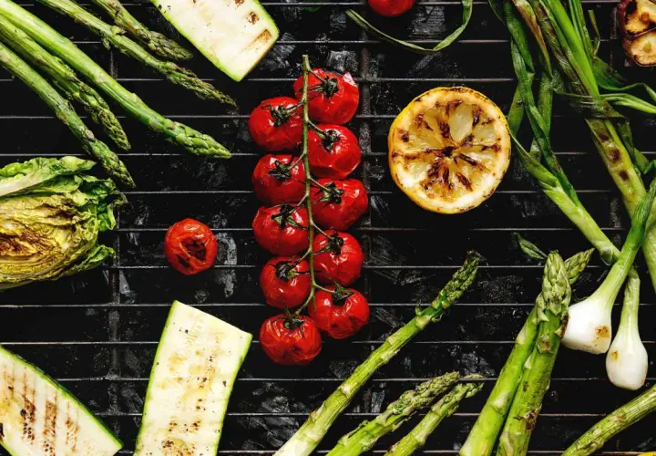 Légumes au barbecue charbon de bois : asperges, tomates cerises, courgettes, oignons nouveaux, citron et chou.