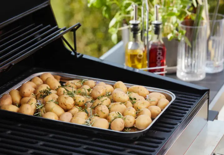 Un plateau de pommes de terre nouvelles assaisonnées d'herbes, prêtes pour le barbecue.