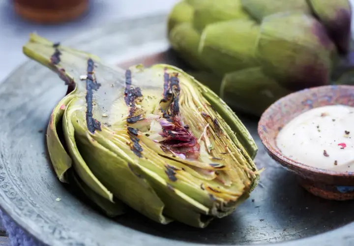 Un délicieux artichaut barbecue, grillé à la perfection, servi avec une sauce crémeuse. Un régal estival !