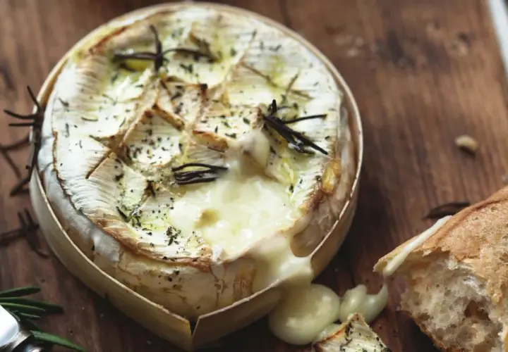 Camembert fondant au romarin, prêt à être dégusté avec une baguette croustillante. Le meilleur camembert au barbecue pour un moment gourmand.