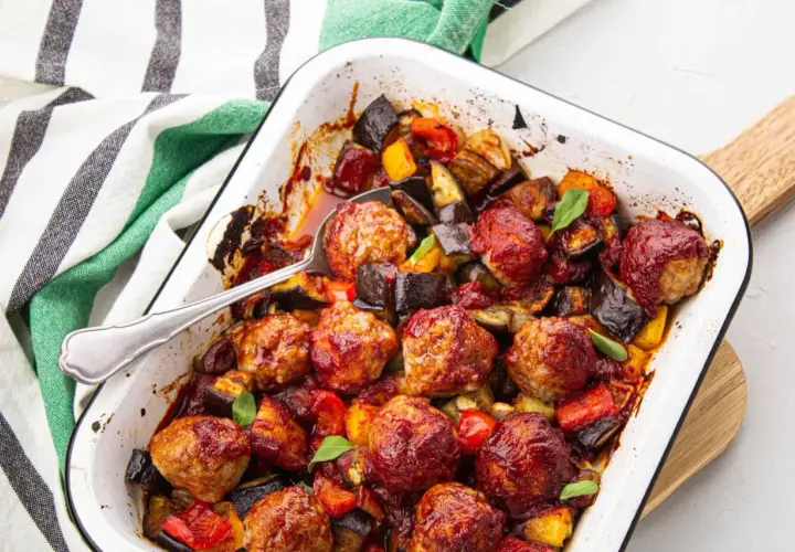 Un plat réconfortant de boulettes de viande barbecue, enrobées d'une sauce savoureuse, mijotant avec des légumes rôtis comme l'aubergine et le poivron.