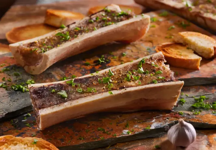 Os à moelle au barbecue, assaisonnés d'herbes et servis avec des toasts grillés et de l'ail. Un délice à savourer !