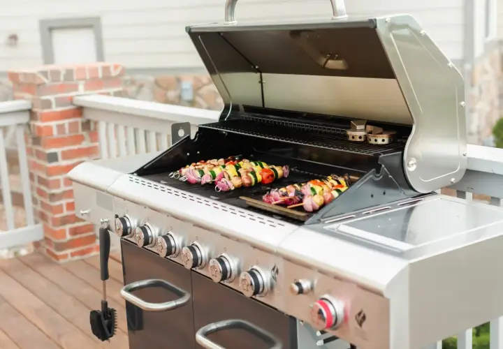 Brochettes colorées en cours de cuisson sur un barbecue à gaz. Les légumes et la viande sont prêts à être dégustés.