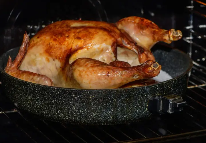 Un poulet crapaudine doré et juteux cuit dans un plat au four, prêt à être dégusté.