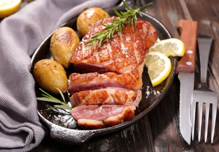 Un délicieux magret de canard au barbecue, servi avec des pommes de terre rôties, du romarin et des quartiers de citron.