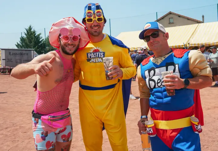 Trois amis costumés pour une soiree brasero, l'un en rose flashy, l'autre en "Pastis Man" jaune, et le dernier en super-héros "Beer".