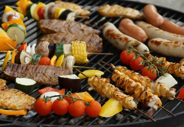 Brochettes de poulet, saucisses, steaks et légumes sur un barbecue. La température parfaite pour un barbecue savoureux.