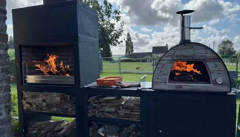 Barbecue et four à pizza en pierre, prêts pour un festin. La grille au fond du barbecue sert à soutenir le bois et à laisser les cendres tomber.